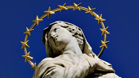 Die Marienstatue in Meran auf dem Sandplatz in Italien zeigt eine junge Frau in Stein mit aufgewühltem Gewand und einem großen Heiligenschein, der mit vielen Sternen geschmückt ist. Die Marienstatue in Meran auf dem Sandplatz in Italien zeigt eine junge Frau in Stein mit aufgewühltem Gewand und einem großen Heiligenschein, der mit vielen Sternen geschmückt ist.