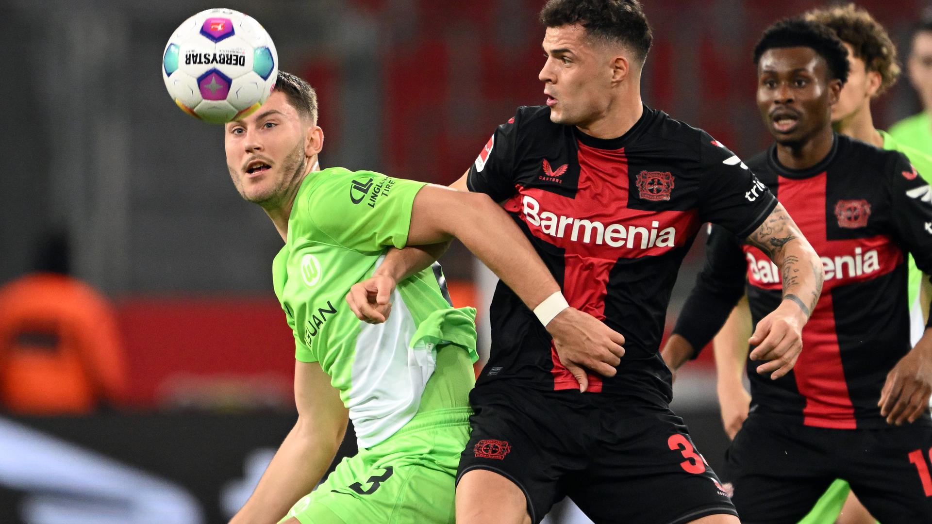 Leverkusens Granit Xhaka und Wolfsburgs Jonas Wind kämpfen um den Ball.