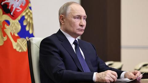 Russlands Staatschef Wladimir Putin sitzt an einem Schreibtisch und schaut ernst.