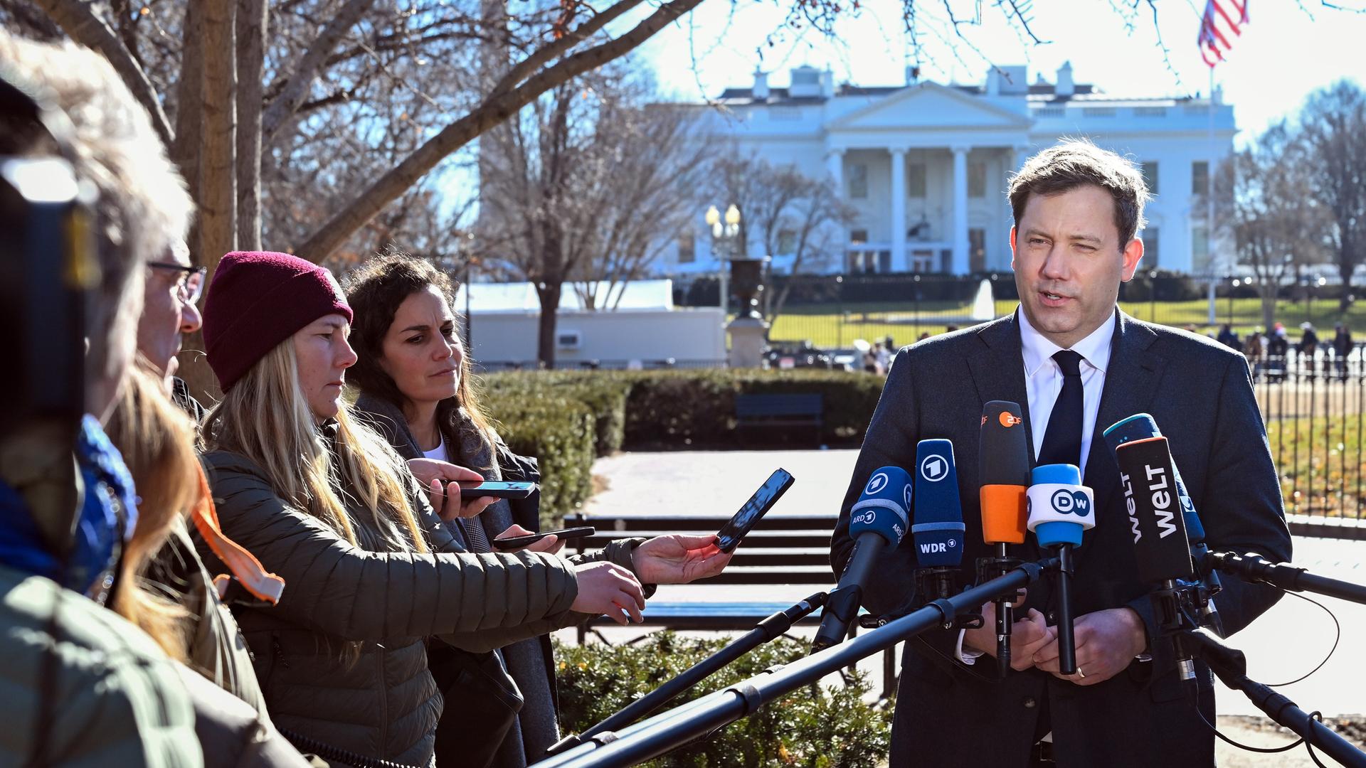 Bundesfinanzminister Lars Klingbeil (SPD) steht vor dem Weißen Haus in Washington und spricht in Mikrofone.