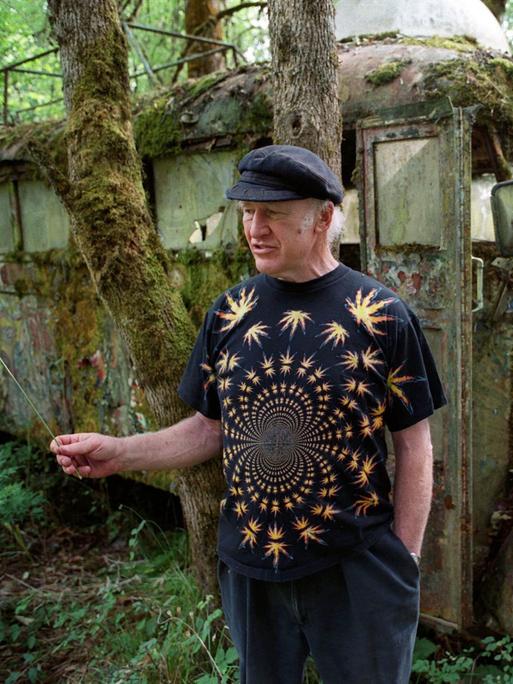 Der amerikanische Schriftsteller Ken Kesey steht im Juli 2001 auf seiner Farm in Pleasant Hill im US-Bundesstaat Oregon vor seinem legendären, ehemals bunt bemalten Bus "Further", der mittlerweile mit Moos bewachsen ist. 