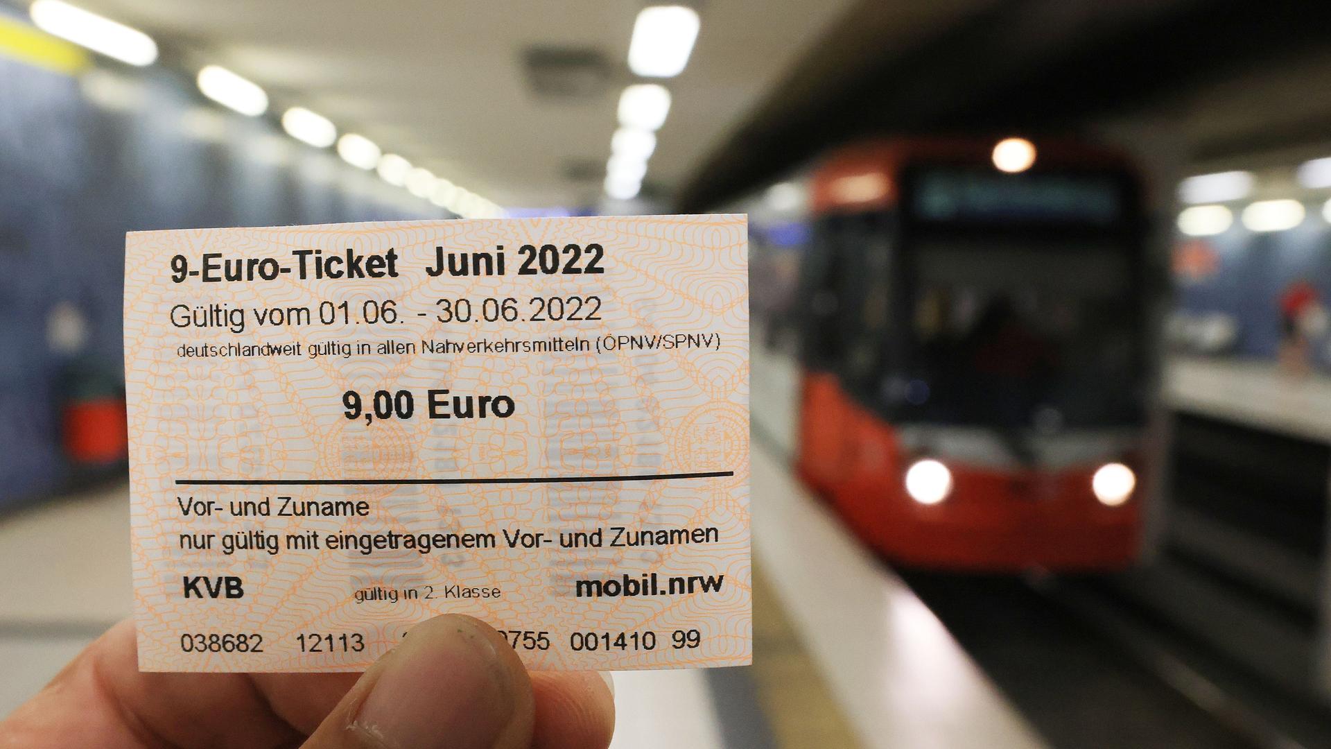 Ein 9-Euro-Ticket für den Monat Juni, im Hinter-Grund steht ein Zug.