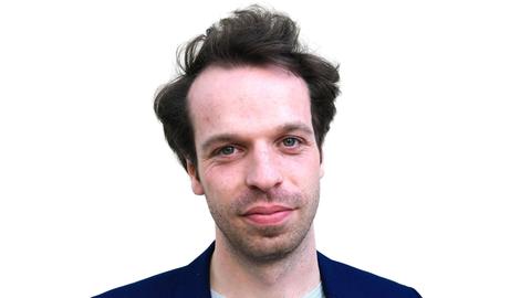 Portrait eines jungen Mannes mit dunkelbraunen kurzen Haaren und dunkelblauem Jackett.
