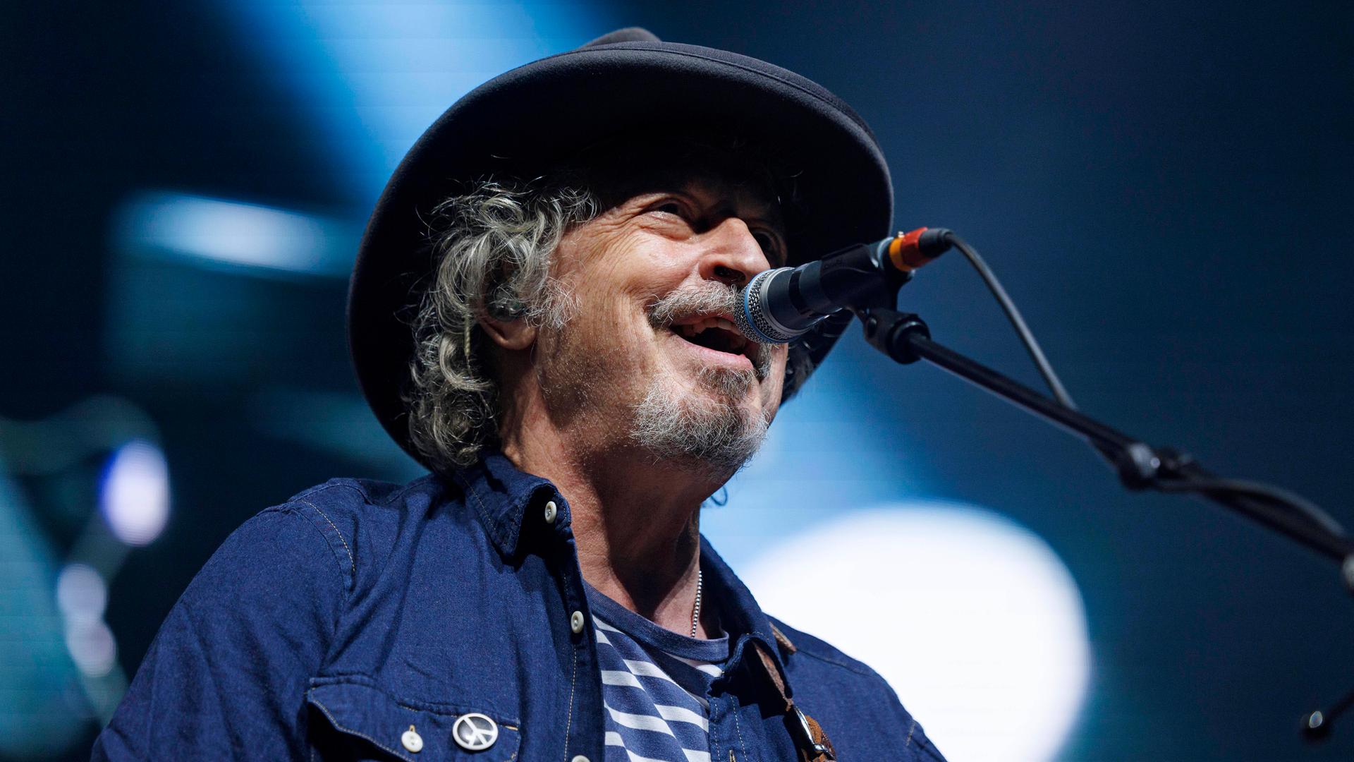 Wolfgang Niedecken singt am 30. März 2022 beim Konzert von Niedeckens BAP in der Lanxess-Arena in Köln in ein Mikrofon. An seinem Jeans-Hemd hängt ein kleiner Button mit Peace-Zeichen. Wolfgang Niedecken singt am 30. März 2022 beim Konzert von Niedeckens BAP in der Lanxess-Arena in Köln in ein Mikrofon. An seinem Jeans-Hemd hängt ein kleiner Button mit Peace-Zeichen.