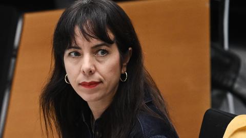 Elif Eralp sitzt im Plenarsaal. Sie hat einen ersten Gesichtsausdruck.