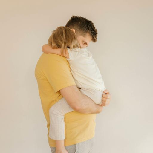 Ein Vater hält seine Tochter tröstend auf dem Arm.