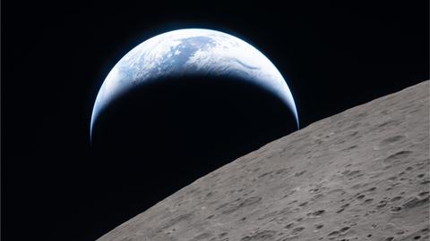 Von der Artemis-Mission aus ist zu sehen, wie die kleinere Erde hintern dem im Vordergrund großen Mond untergeht.