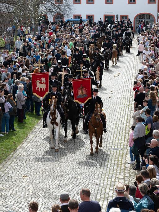 Traditionell gekleidete sorbische Osterreiter verkünden nach altem Brauch zu Pferde im Kloster St. Marienstern die Osterbotschaft. Begleitet wird die Prozession von vielen Schaulustigen am Wegesrand.