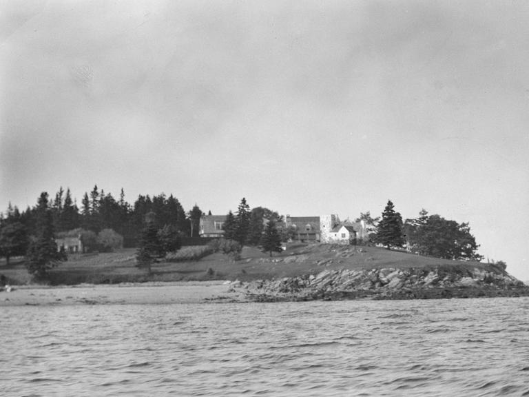 Maine, USA, 1931: Das Foto zeigt eine steinige Insel mit Holzhäusern darauf.