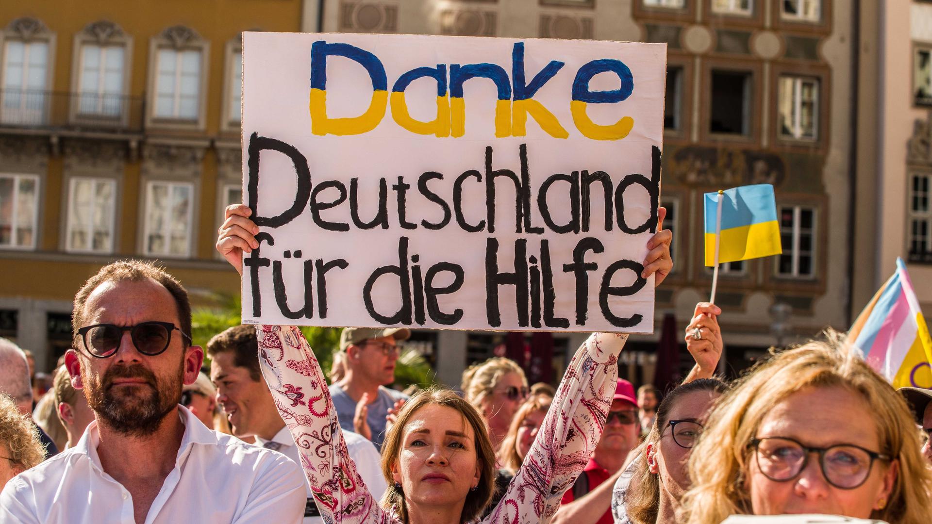 Eine Frau hält auf einer Demo ein Schild hoch mit der Aufschrift: "Danke Deutschland für die Hilfe" Eine Frau hält auf einer Demo ein Schild hoch mit der Aufschrift: "Danke Deutschland für die Hilfe"