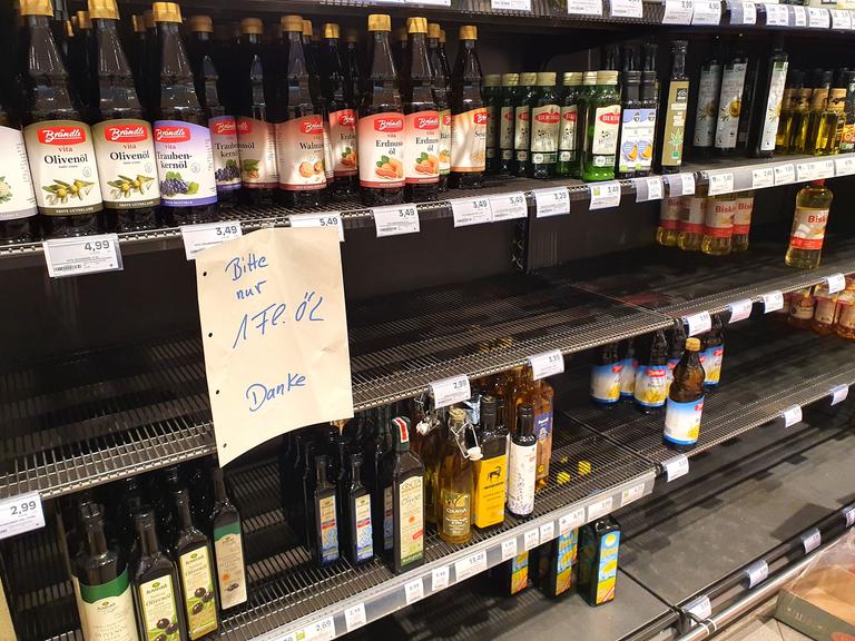 In einem Supermarkt hängt an einem leere Speiseöl-Regal der Hinweis, dass Verbraucher nur jeweils eine Flasche kaufen dürfen. 