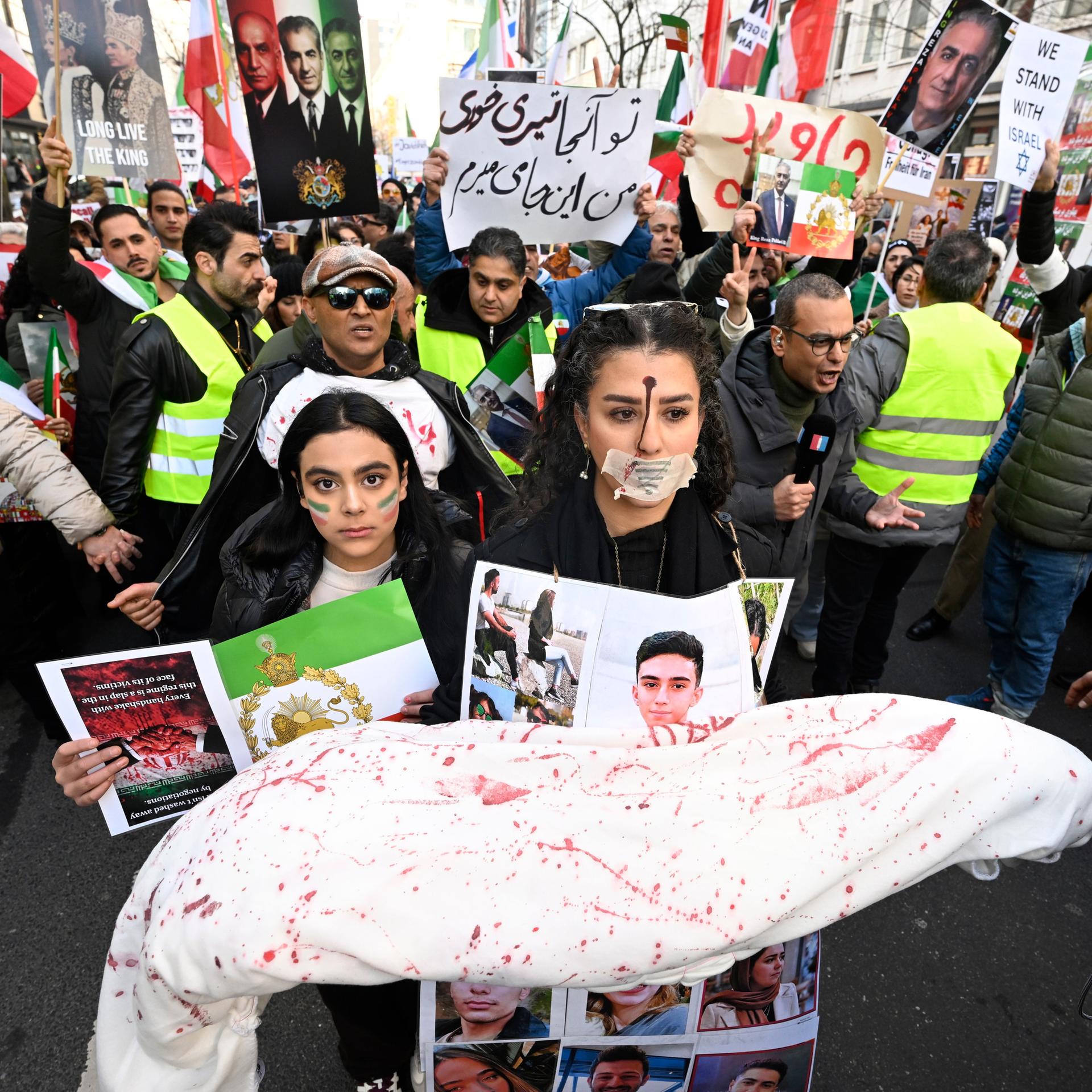 Tausende Menschen protestieren in Düsseldorf gegen das Regime im Iran. Viele halten Transparente hoch. 