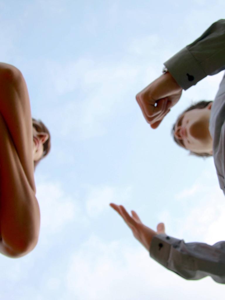 Zwei Menschen, die sich gegenüber stehen, sind aus der Froschperspektive aufgenommen, sie scheinen sich über etwas zu streiten. Zwei Menschen, die sich gegenüber stehen, sind aus der Froschperspektive aufgenommen, sie scheinen sich über etwas zu streiten.