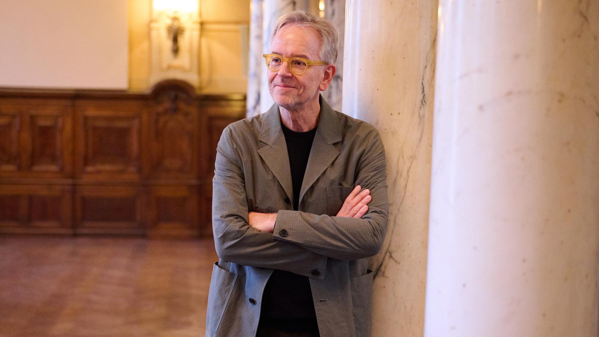 Oliver Reese, Intendant des Berliner Ensembles, steht im Theater an einer Säule.