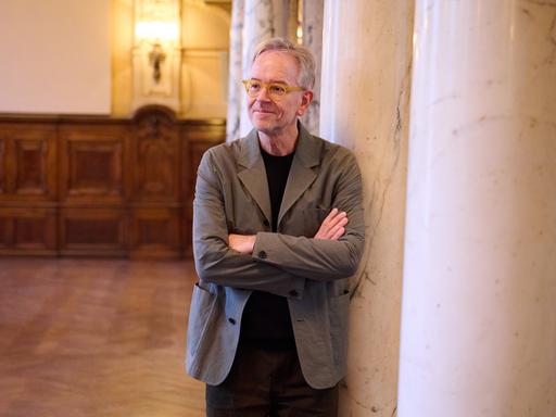 Oliver Reese, Intendant des Berliner Ensembles, steht im Theater an einer Säule.
