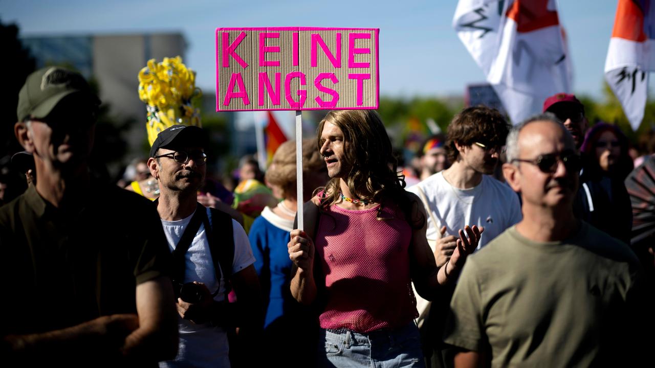 Teilnehmer des CSD halten ein Schild mit der Aufschrift "Keine Angst" in die Luft