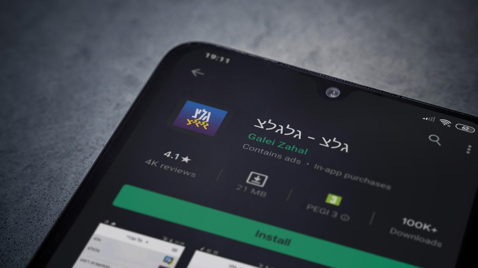 Galei-Zahal-App-Seite im Play Store auf dem Display eines schwarzen Smartphones vor dunklem Marmorhintergrund.