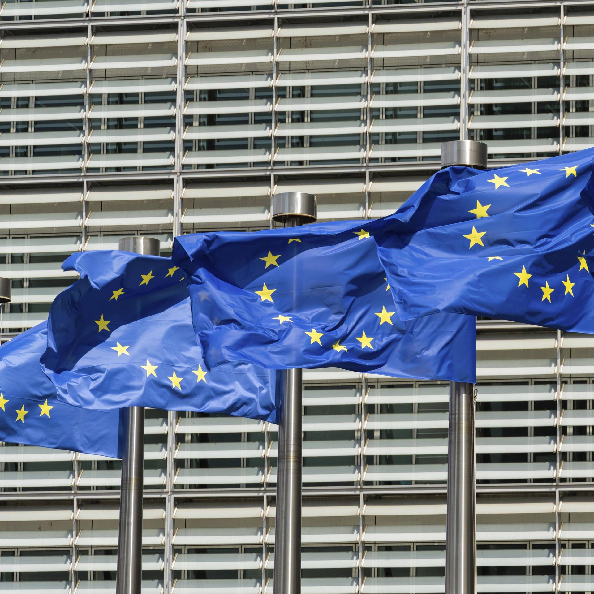 Blaue Flaggen der Europäischen Union vor dem Gebäude der Europäischen Kommission in Brüssel. 