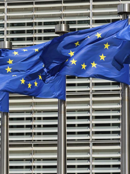 Blaue Flaggen der Europäischen Union vor dem Gebäude der Europäischen Kommission in Brüssel. 