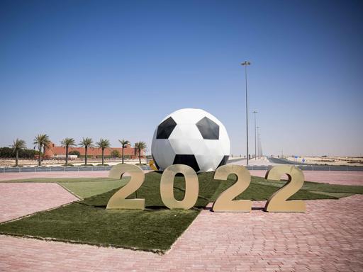 Ein großer Ball mit der Jahreszahl 2022 steht auf einer Verkehrsinsel mit Kreisverkehr vor dem Trainigsgelände Al-Shamal sports Club in der Hafenstadt Al Ruwais.