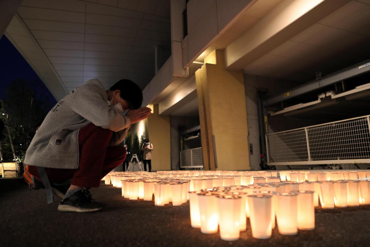 Ein Angehöriger gedenkt der Opfer und betet vor einer großen Anzahl weißer Kerzen am Ort des Geschehens: Das Zugunglück in Amagasaki in Japan jährte sich 2020 zum 15. Mal.