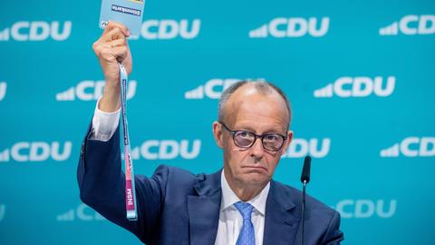 Friedrich Merz hält beim CDU-Bundesparteitag eine Stimmkarte hoch. 