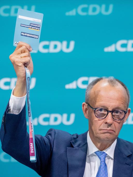 Friedrich Merz hält beim CDU-Bundesparteitag eine Stimmkarte hoch. 