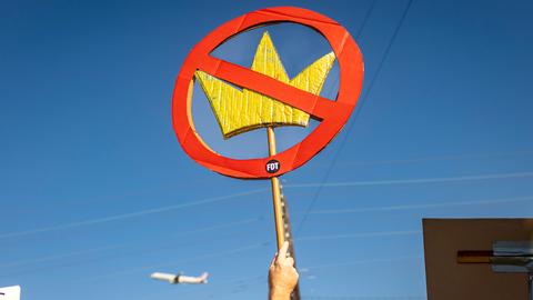Ein Demonstrant hält bei einer Kundgebung gegen US-Präsident Trump ein Schild mit einer durchgestrichenen Königskrone hoch.
