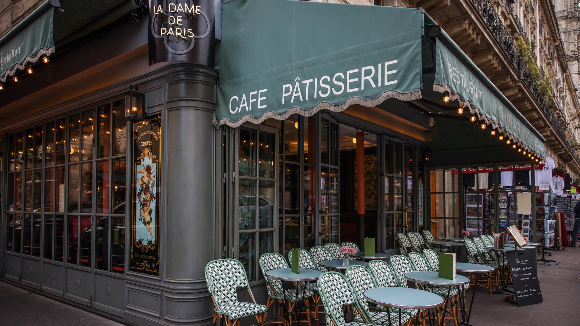 Vor einem Bistro in Paris sind Stühle und Tische aufgestellt.