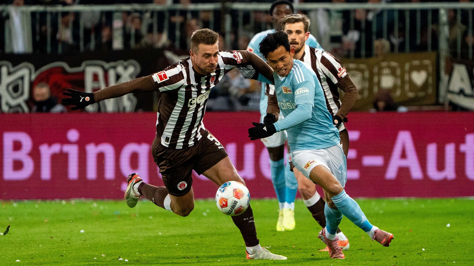 Hauke Wahl (FC St. Pauli Hamburg) im Zweikampf, Kampf um den Ball mit Wooyeong Jeong (Union Berlin)