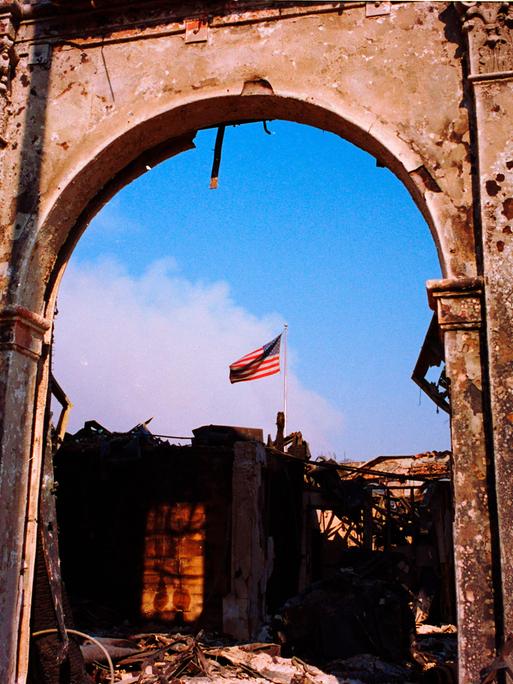 Ein Blick auf ein vom Feuer zerstörtes Gebäude gibt den Blick auf die amerikanische Flagge frei.