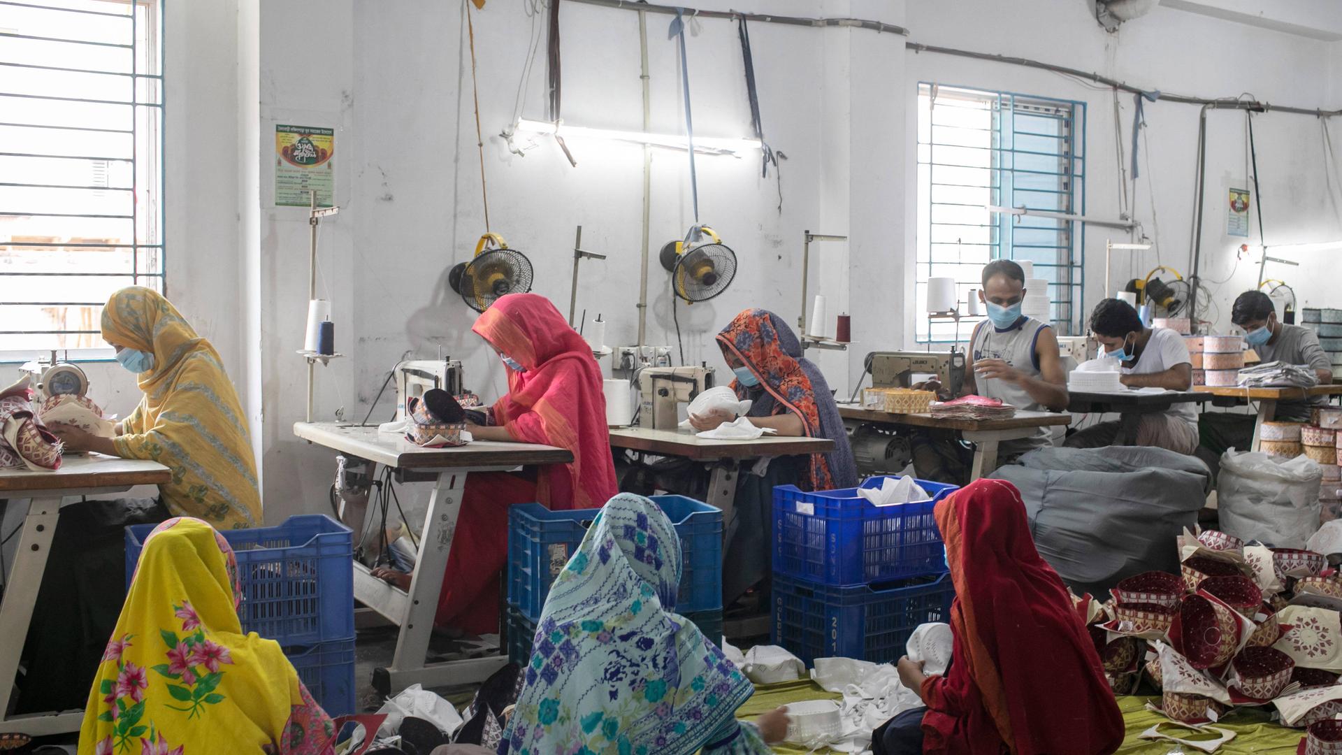 Eine Fabrik in Bangladesh mit Arbeiterinnen und Arbeitern an Nähma