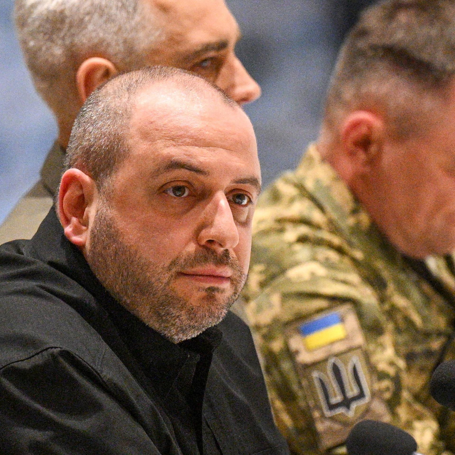 Das Bild zeigt den Leiter der ukrainischen Delegation, Verteidigungsminister Rustem Umerov, sitzend im schwarzen Oberteil. Im Hintergrund sitzen ukrainische Militärangehörige in Tarnanzügen. 