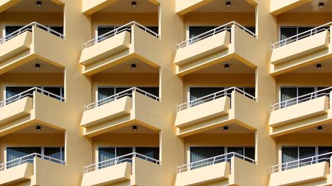 Blick auf ein mehrstöckiges Wohnhaus mit gelber Fassade und vielen Balkonen