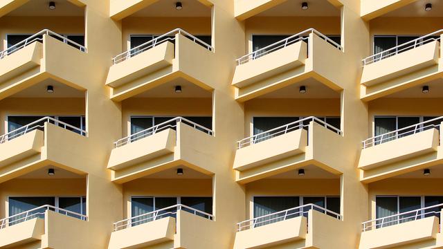 Blick auf ein mehrstöckiges Wohnhaus mit gelber Fassade und vielen Balkonen