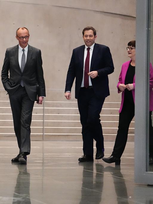 Markus Söder, Friedrich Merz, Lars Klingbeil und Saskia Esken laufen nebeneinander durch eine Tür zu einer Pressekonferenz.