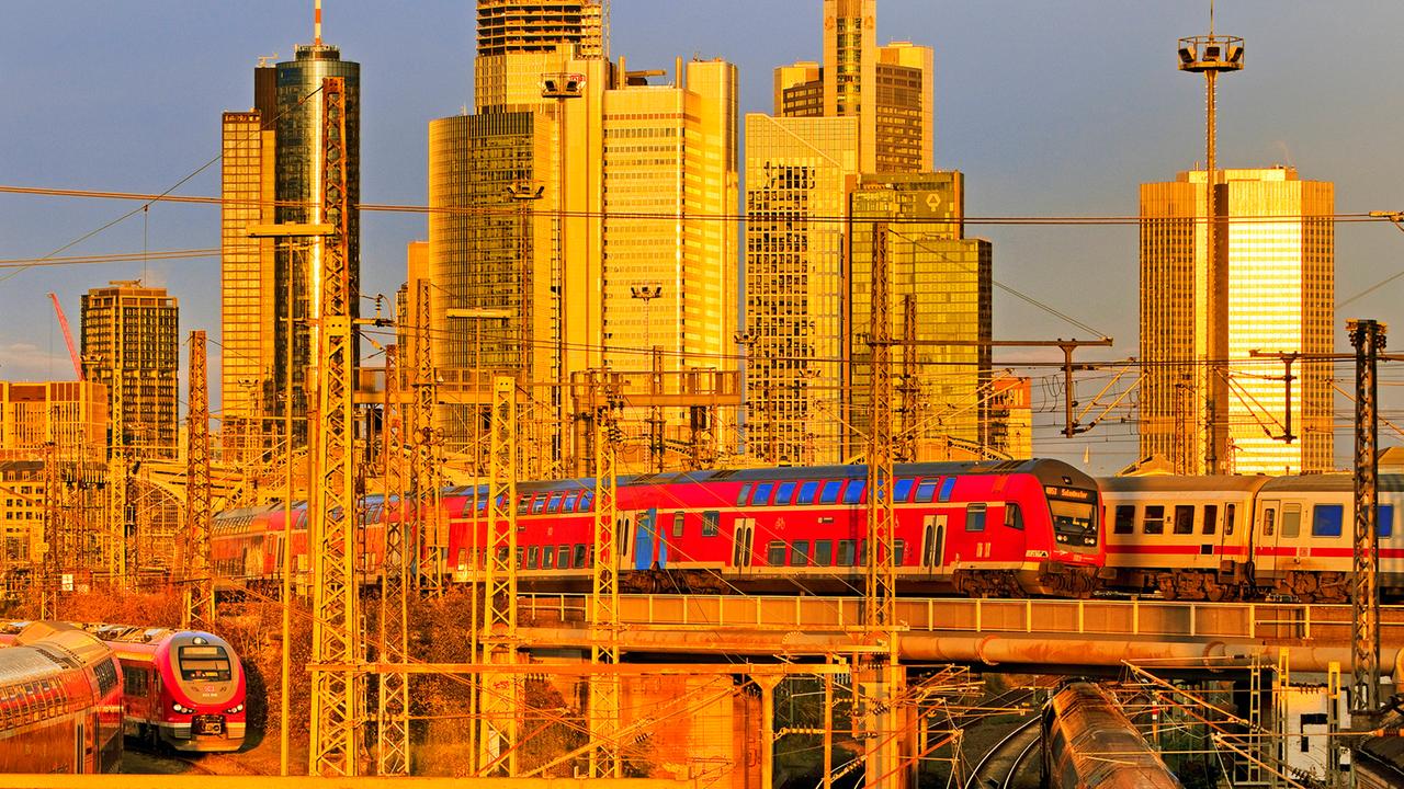 Eine erhöhte Stadtansicht mit vielen Regionalzügen, dem Hauptbahnhof und Hochhäusern in Frankfurt am Main, 2024.