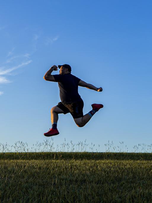 Ein Mann, der in der Landschaft in die Luft hüpft. Ein Mann, der in der Landschaft in die Luft hüpft.