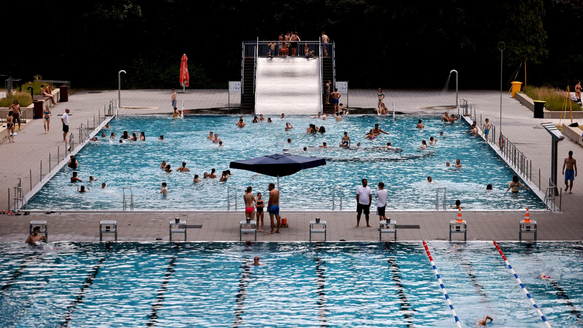 Blick auf das Kölner Stadionbad mit Schwimmer- und Nichtschwimmerbecken und einer Rutsche