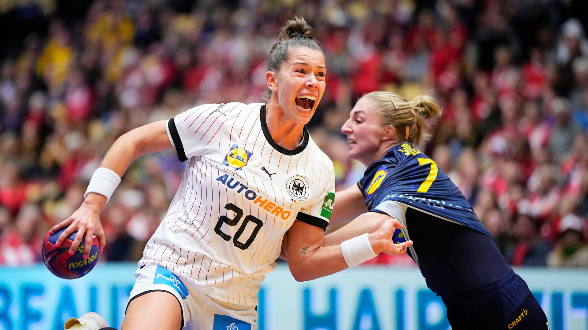 Auf dem Bild sieht man die deutsche Handballerin Emily Bölk. Sie will den Ball auf das Tor werfen. Linn Blohm aus Schweden will das verhindern.