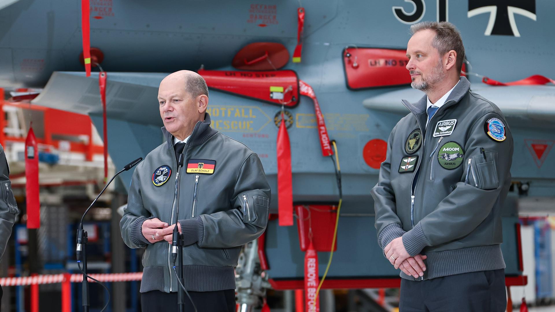 Bundeskanzler Scholz und Mike Schöllhorn, CEO der Airbus Defence and Space, in der Endmontage-Halle des Eurofighter-Kampfflugzeugs
