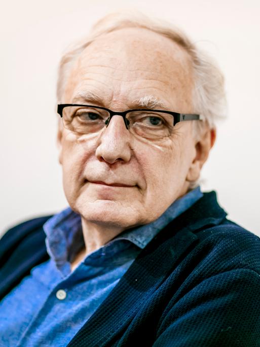 Ein weißhaariger Mann mit dunkler Brille, dunklem Sakko und blauem Hemd. Es ist der Politikwissenschaftler Claus Leggewie.