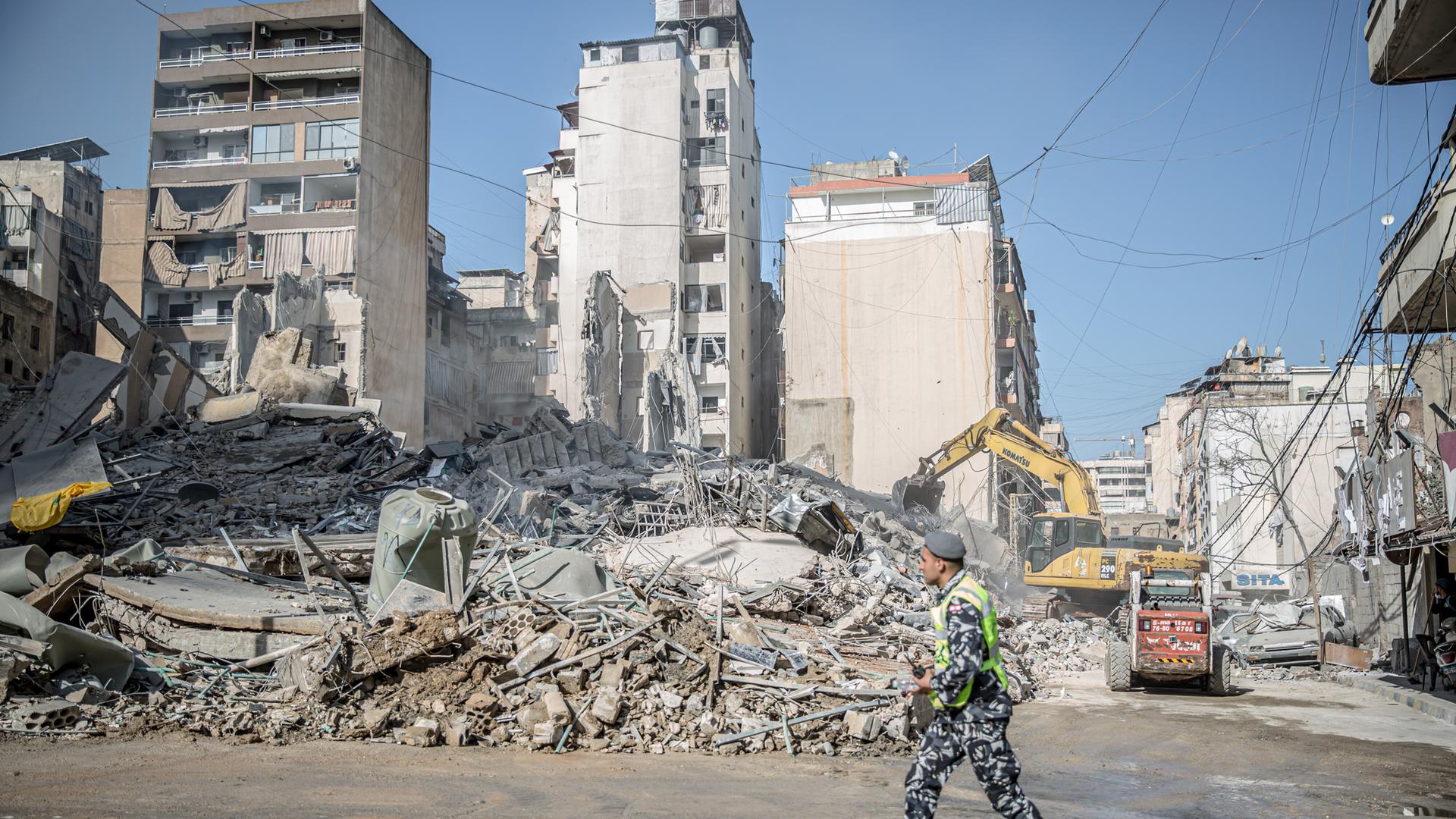 Ein Polizist geht in Bachoura im Libanon an einer völlg zerstörten Häuserreihe entlang.