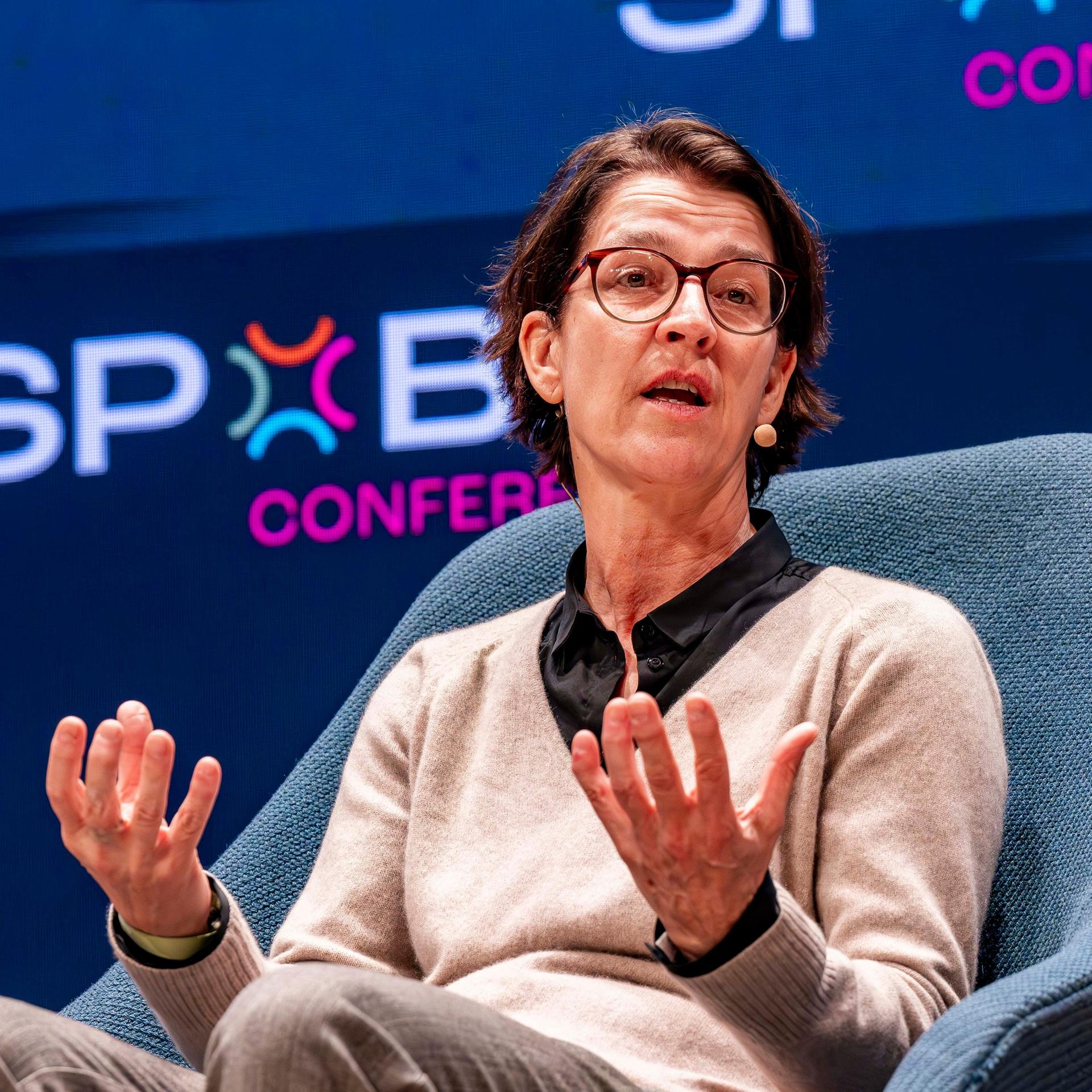 Tatjana Haenni sitzt in einem Sessel und gestikuliert mit beiden Händen.