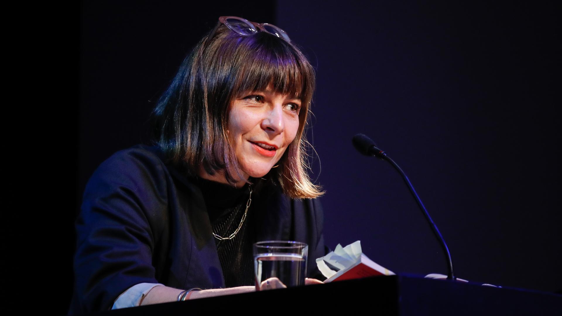 Frau an einem Rednerpult: die Schriftstellerin Uljana Wolf. Frau an einem Rednerpult: die Schriftstellerin Uljana Wolf.