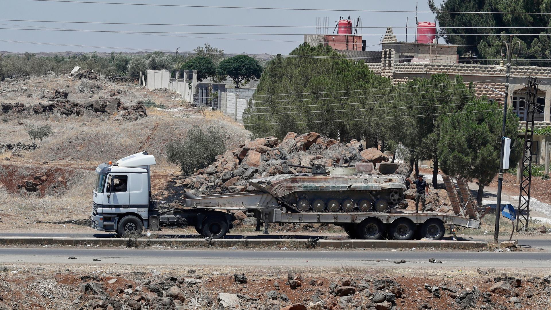 Ein auf einem Lastwagen transportierter Panzer der syrischen Regierungstruppen, die sich aus der Stadt Suweida zurückziehen, passiert das Dorf Mazraa. 