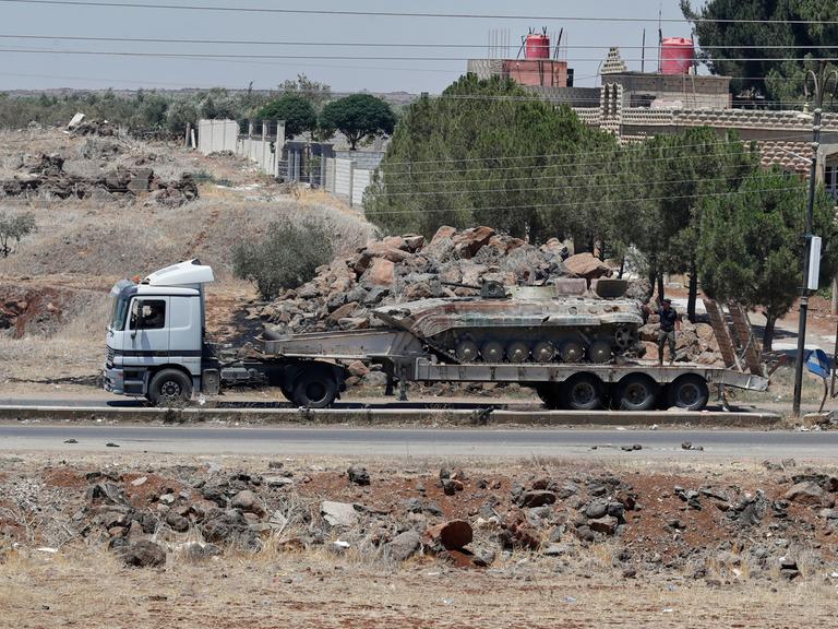 Ein auf einem Lastwagen transportierter Panzer der syrischen Regierungstruppen, die sich aus der Stadt Suweida zurückziehen, passiert das Dorf Mazraa. 