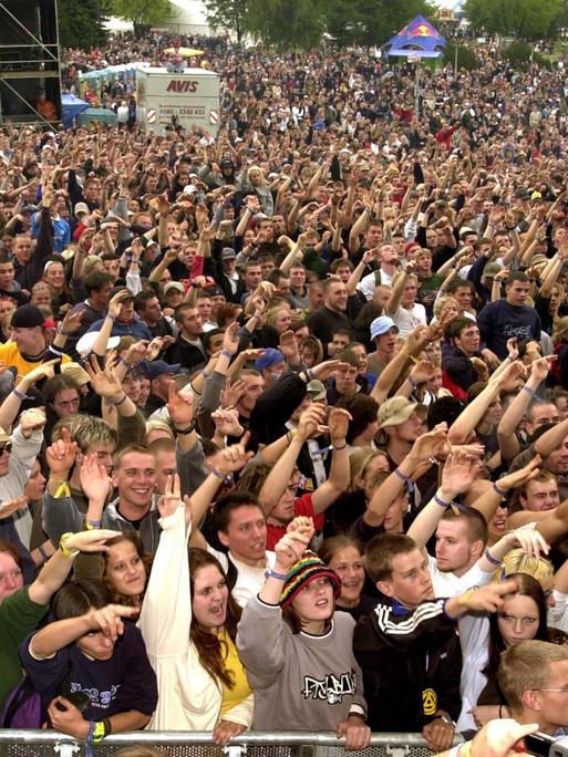 Ausgelassene Stimmung herrscht am Abend des 22.07.2000 unter den 20.000 Fans am Stausee Oberrabenstein bei Chemnitz beim Hip Hop-Festival "Splash!". Es ist eine große Menschenmenge zu sehen, die die Arme in die Luft hebt und Richtung Bühne schaut.