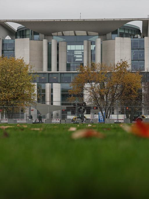 Ein Mensch recht Laub vor dem Kanzleramt. Am Mittwochabend entließ der Bundeskanzler den Finanzminister und kündige Neuwahlen für das kommende Frühjahr an.