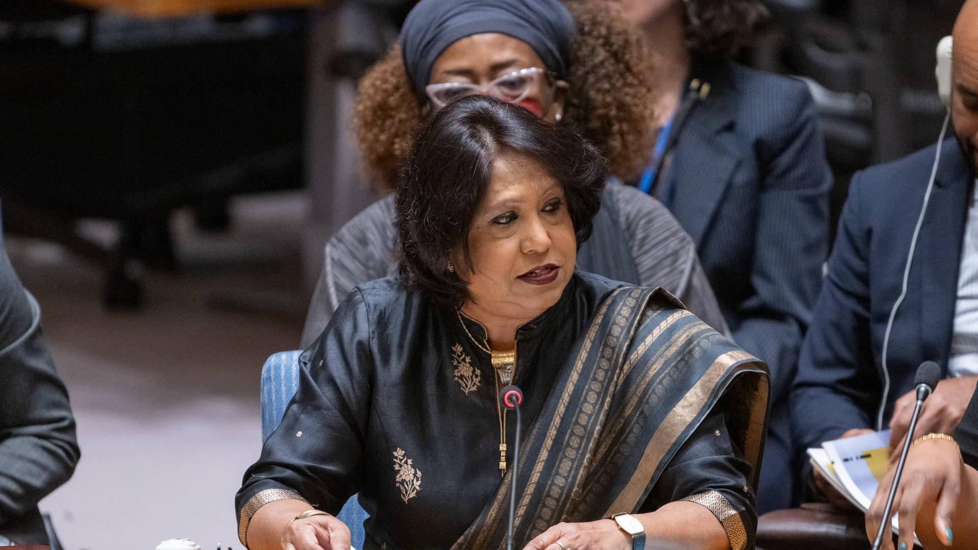Die UNO-Sonderbeauftragte für sexuelle Gewalt in Konflikten, Pramila Patten, sitzt an einem Pult, vor ihr steht ein Mikrofon.